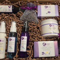 Overhead view of lavender lotion, shower gel, room spray, soaps, body butter and sachets