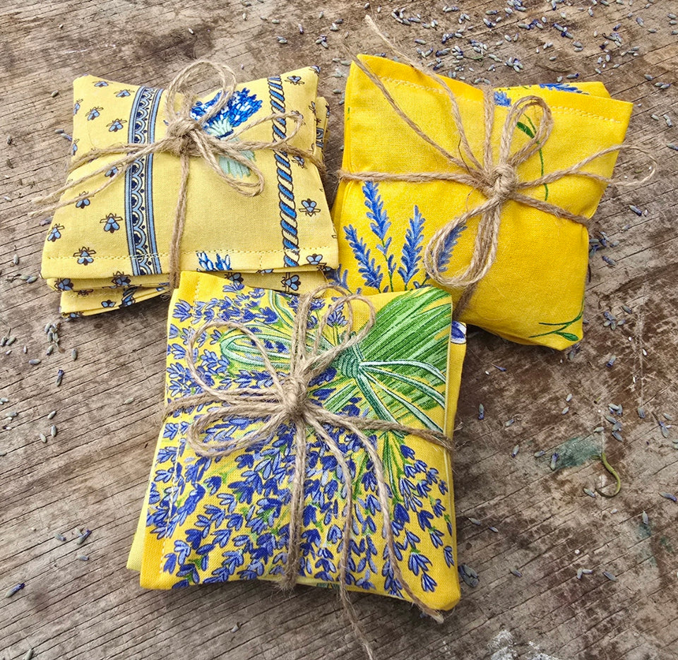 Three sets of handmade lavender dryer sheets in yellow Provence-print cotton tied with jute